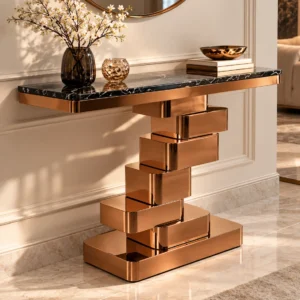 Luxury black marble entryway console table with copper-tone stepped pedestal styled beneath a round wall mirror with flowers and books.