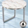 Orviana Luxe silver sphere marble side table with asymmetric stainless steel legs on a light blue background