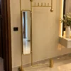 Solvane gold standing mirror with coat rack in modern entryway