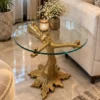 Gold finish tree branch glass side table with sculptural bear detail displayed beside a cream sofa