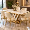 Modern marble dining table with gold V pedestal and upholstered chairs