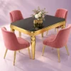 Designer black and gold marble dining table with pink upholstered chairs