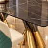 Close up of black marble dining table and sculptural gold stainless steel base