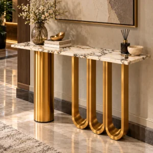 Angled view of a designer white marble console table with gold stainless steel cylinder and three sculptural loop legs.