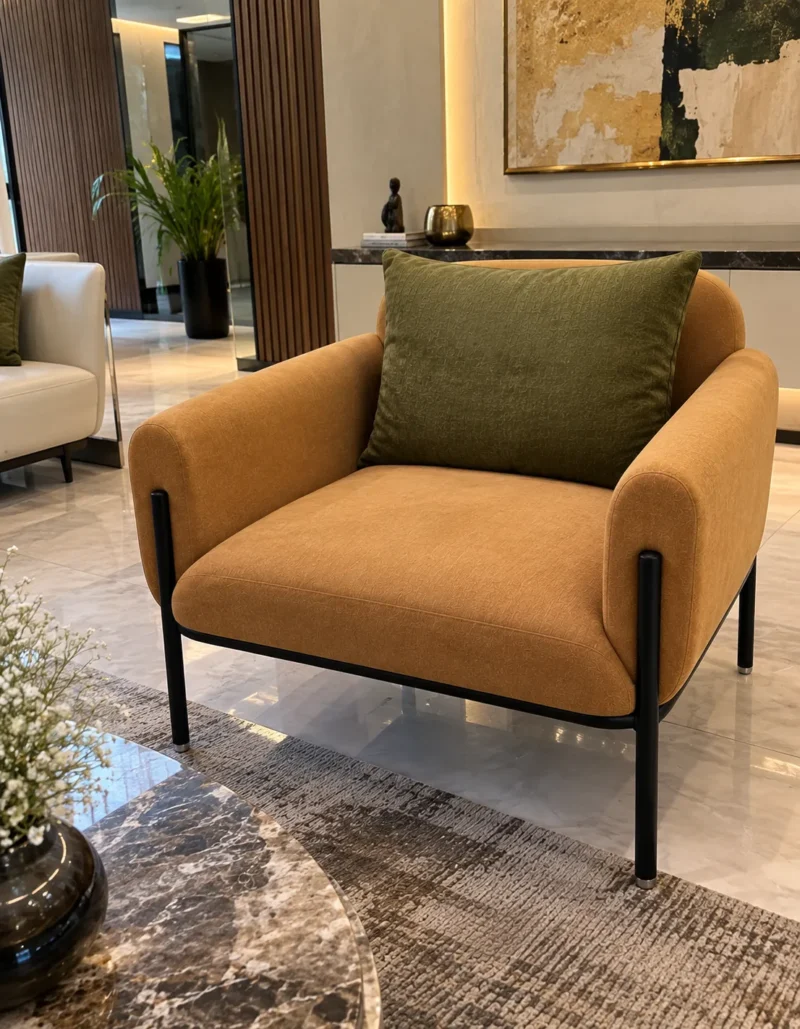 Caramel fabric accent chair with olive-green back cushion and black stainless steel legs in a contemporary luxury interior.