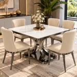 Luxury square marble dining table with dark metallic curved pedestal and six cream fabric dining chairs in a contemporary interior.