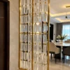 Gold stainless steel partition with linked Premix Glas beside a luxury dining room