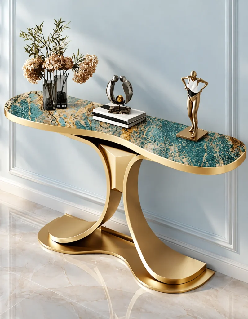 Modern teal marble console table with gold stainless steel curved base against a light blue wall with decorative sculptures.