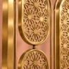 Close-up of intricate floral starburst lattice on gold stainless steel partition