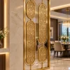 Decorative oval floral metal partition with gold frame beside marble wall