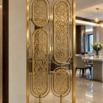 Modern gold room divider with four oval floral panels beside dining room