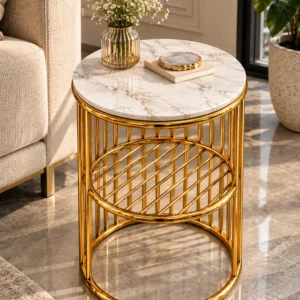 Designer round marble side table with gold stainless steel lattice shelf placed next to a luxury sofa