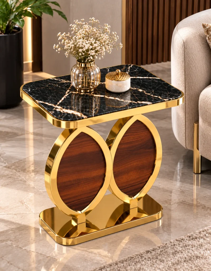 Designer gold marble side table with black rectangular top and sculptural dual oval base beside a cream sofa.